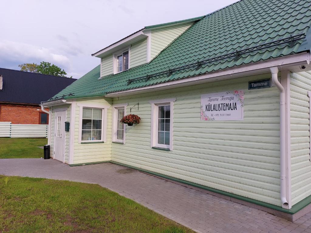 a white house with a sign on the side of it at Tamme Teemaja in Iisaku