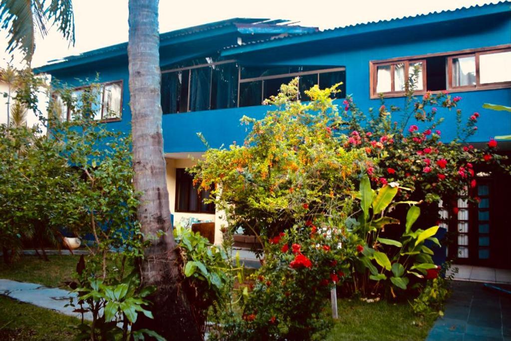 a blue house with flowers in front of it at B&B JPA Casa ANSELMO in Salvador