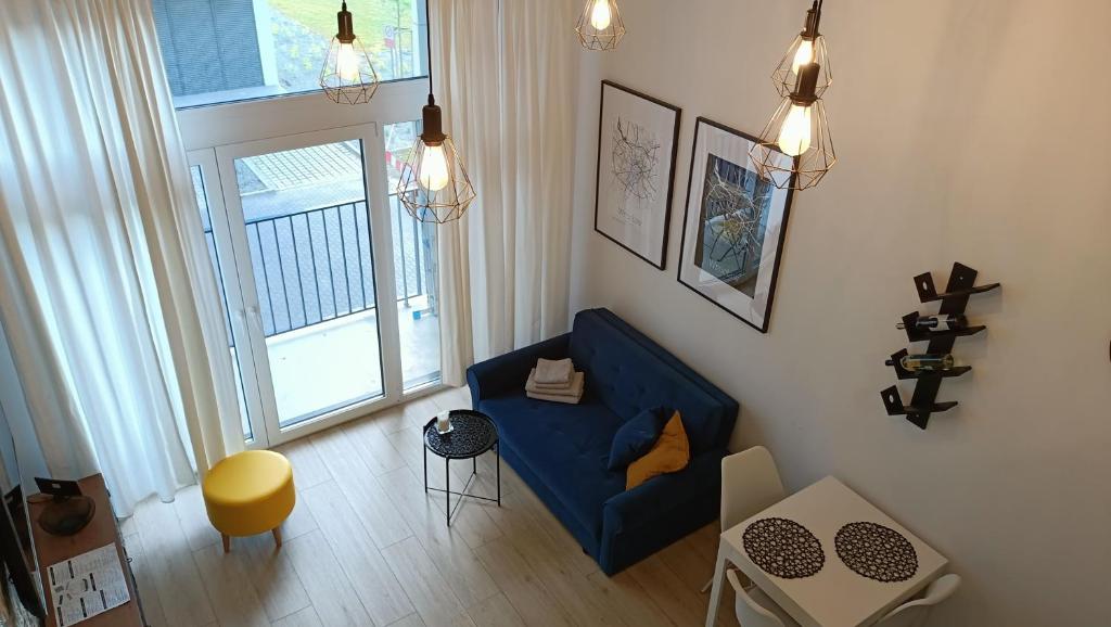 sala de estar con sofá azul y ventana en DROINVEST Apartament Zarembowicza WROCŁAW LOTNISKO AIRPORT - FV, en Wroclaw