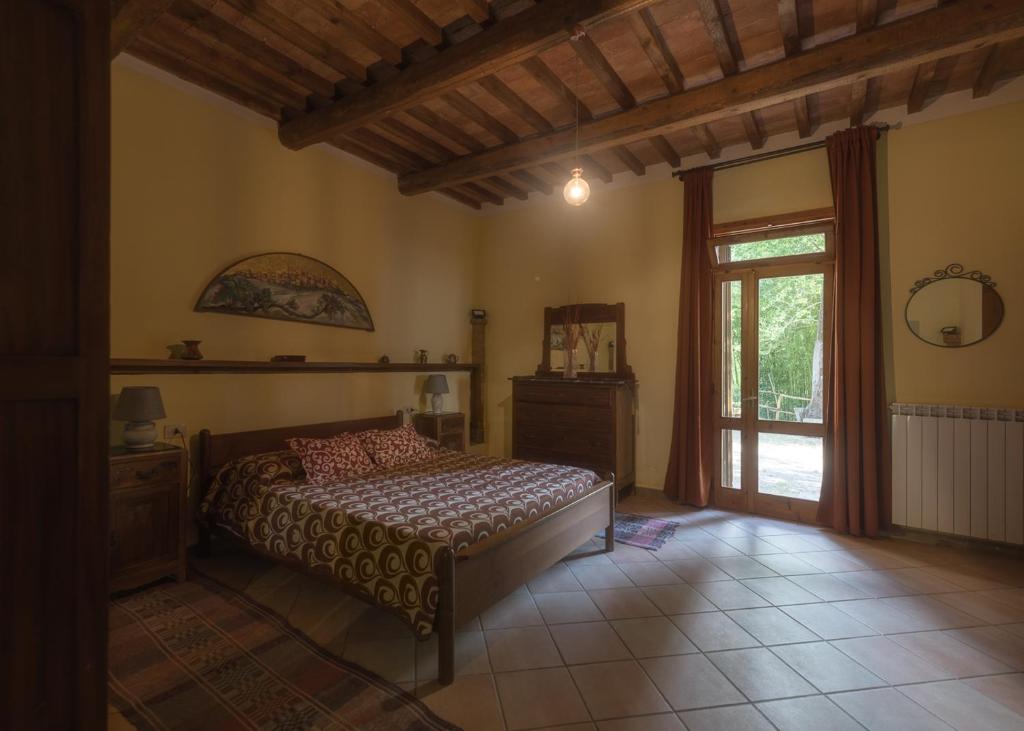 1 dormitorio con 1 cama en una habitación con ventana en Casa nel bosco Il Grottone, en Montaione
