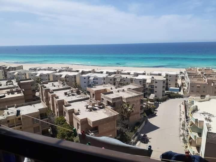 Blick auf einen Strand mit Gebäuden und das Meer in der Unterkunft Free Wi-Fi شقة فندقية فى الاسكندرية New apartment sea view Alexandria in Alexandria