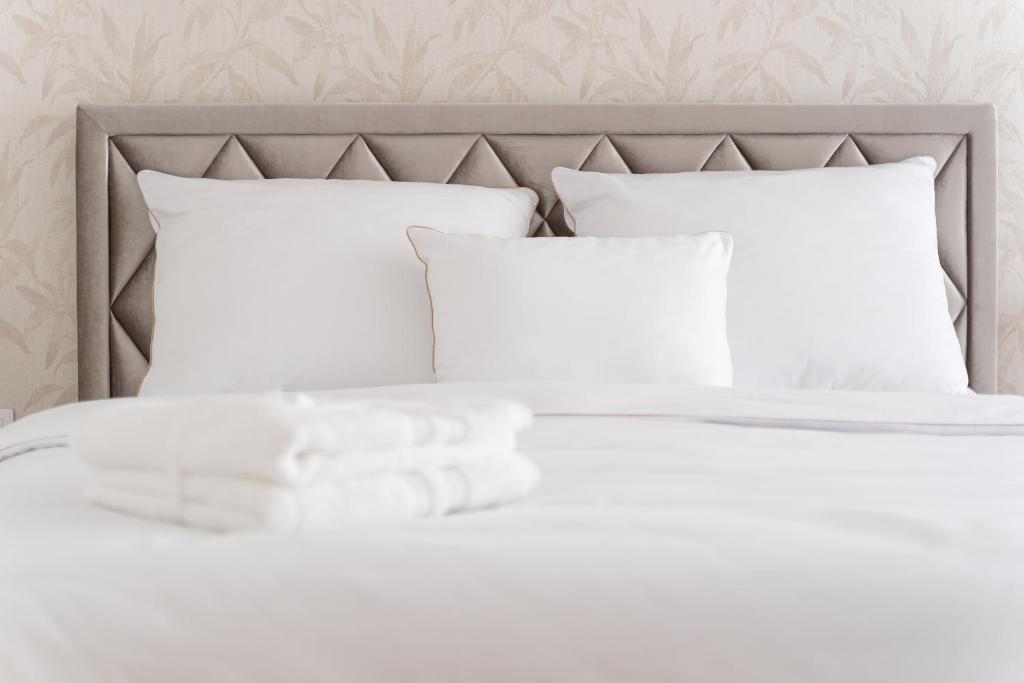 uma cama com lençóis brancos e almofadas em APARTAMENT STARE MIASTO UL. WIELKA ODRZAŃSKA SZCZECIN em Szczecin