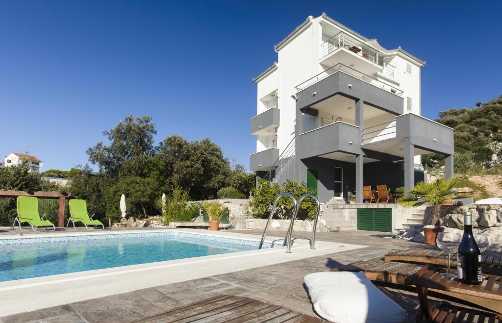 une villa avec une piscine et un bâtiment dans l'établissement Cipra Apartments, à Okrug Donji