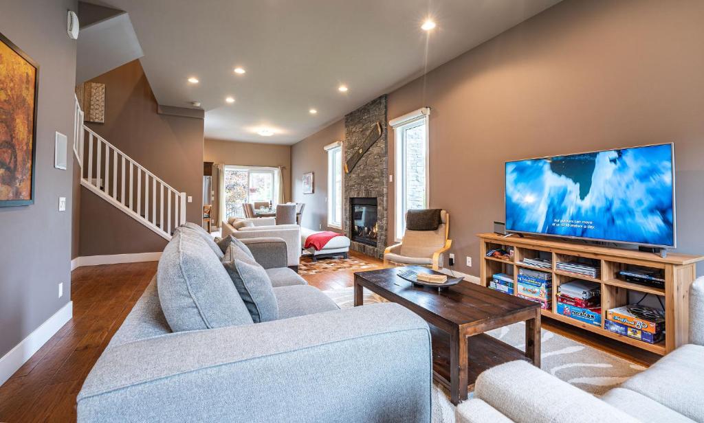 uma sala de estar com uma grande televisão de ecrã plano em Aspen Lodge by Revelstoke Vacations em Revelstoke