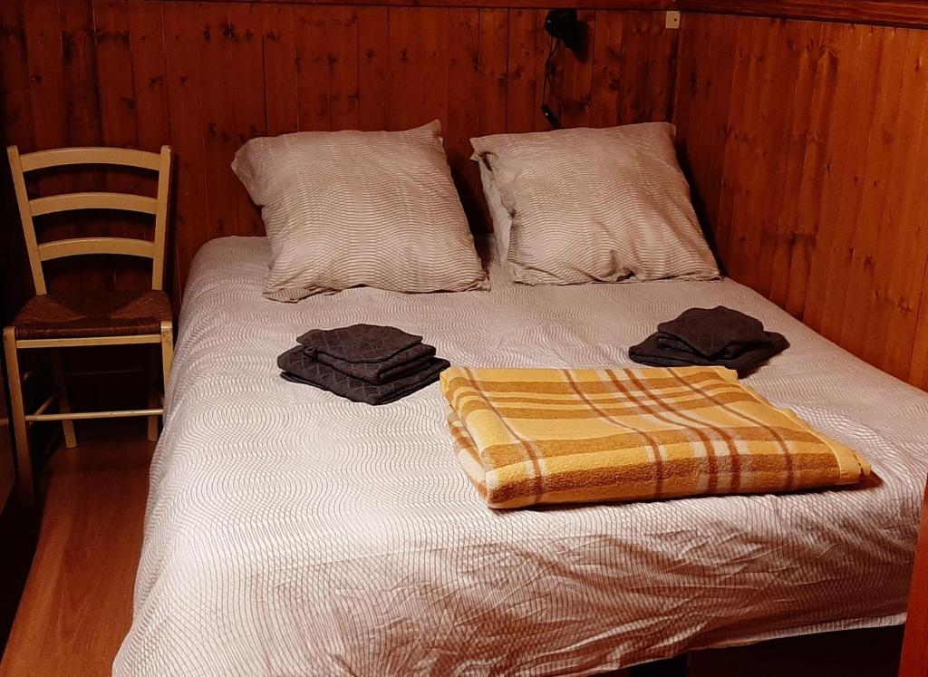 un letto con due cuscini e una coperta sopra di Châlet vue lac Léman à 1000 mètres d altitude a Meillerie