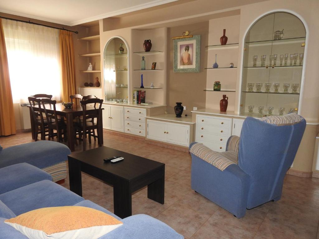 uma sala de estar com cadeiras azuis e uma mesa em La Morada Casa Rural em Bolaños de Calatrava