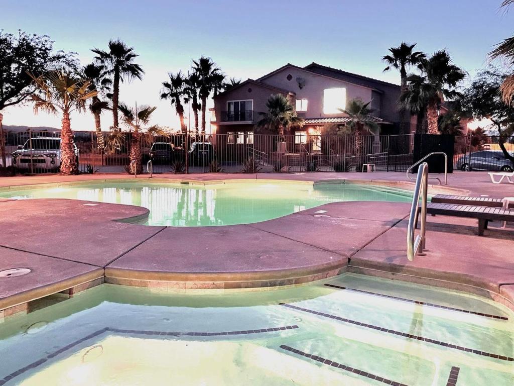 einen Pool mit einer Bank und Palmen in der Unterkunft North Shore Inn at Lake Mead in Moapa Valley