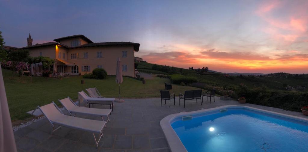 a villa with a swimming pool in front of a house at Agriturismo La Casa in Collina in Canelli