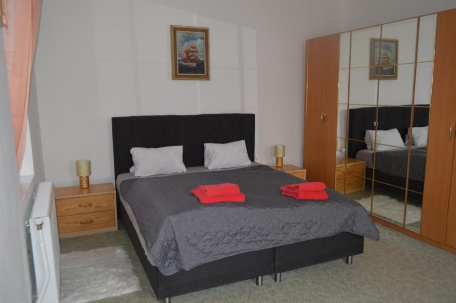 a bedroom with a bed with two red towels on it at Bohemica Apartman 1 in Kouřim