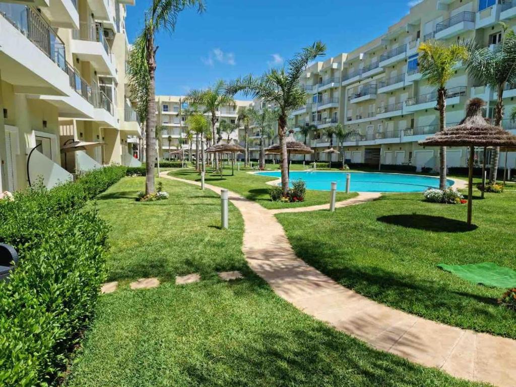 un complexe avec une piscine et un bâtiment dans l'établissement Lux Apartment In Bouznika With Pool, à Bouznika