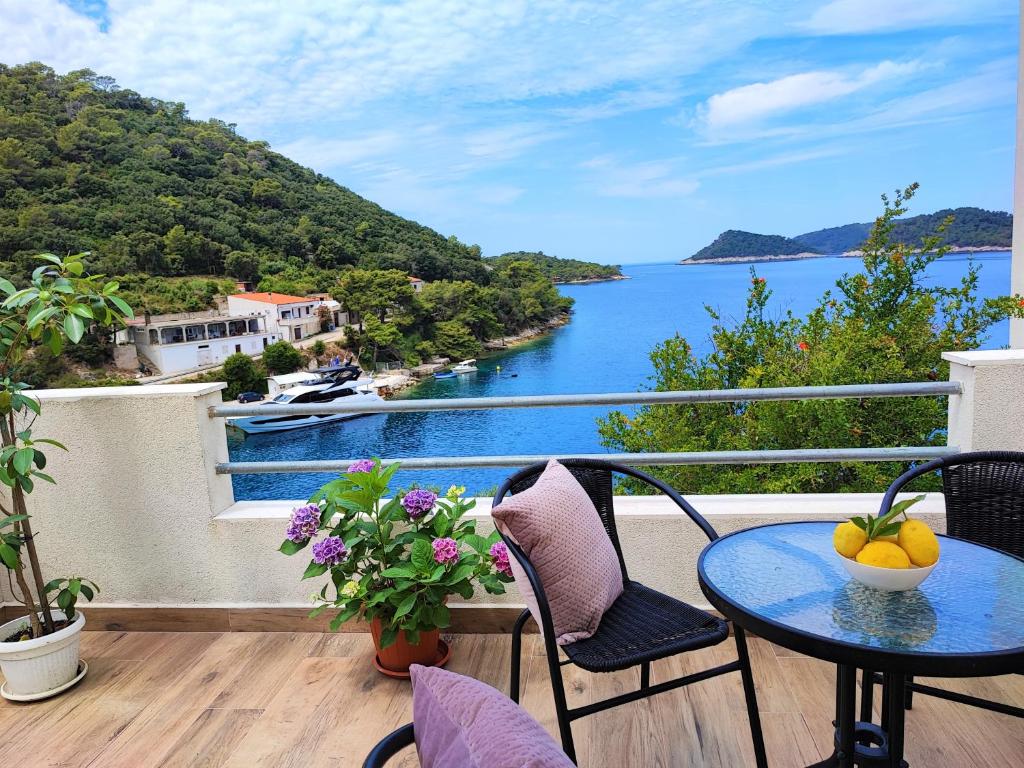 einen Balkon mit einem Tisch und Stühlen sowie Blick auf das Wasser in der Unterkunft Apartment Jole in Lastovo