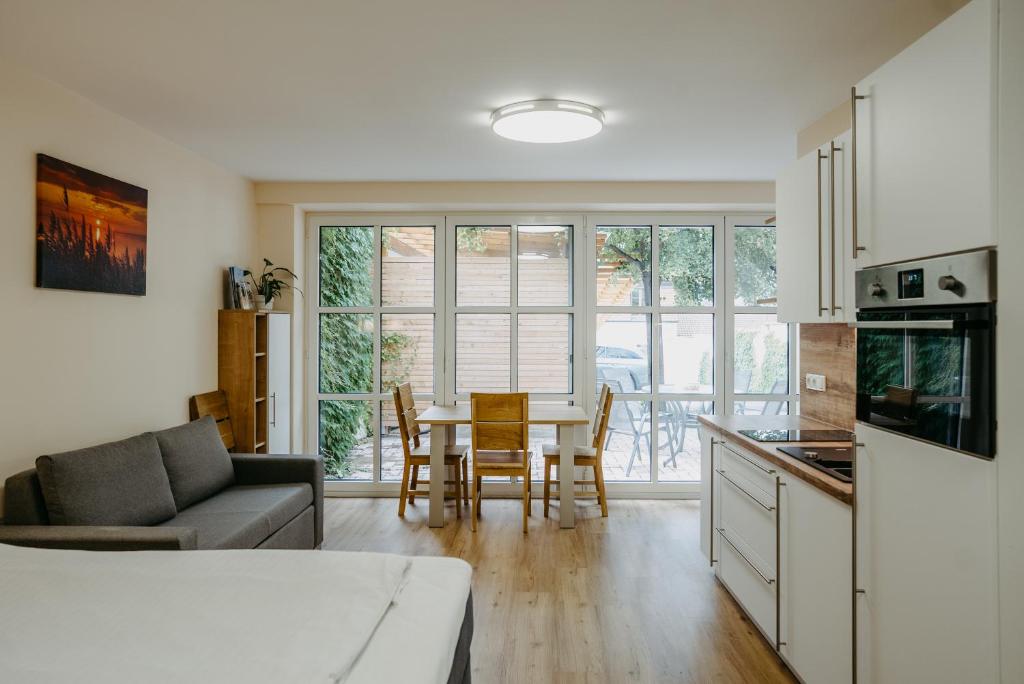 eine Küche und ein Wohnzimmer mit einem Tisch und Stühlen in der Unterkunft Chill & Relax Apartments in Neusiedl am See in Neusiedl am See