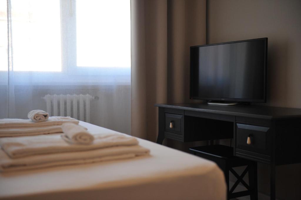 sypialnia z telewizorem na komodzie z ręcznikami w obiekcie Vatican Holiday Home w Rzymie