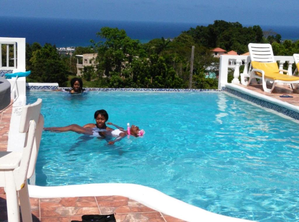 un jeune enfant dans une piscine avec un jouet dans l'établissement Sunflower Nest, à Runaway Bay