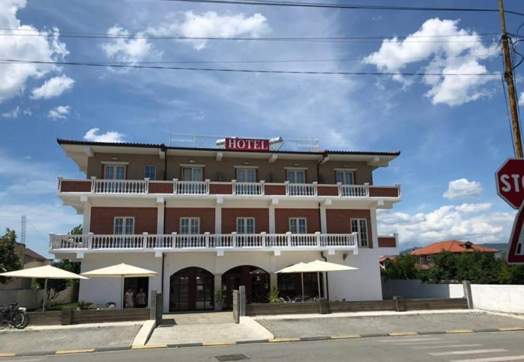 un hotel en la esquina de una calle con una señal de stop en Hotel Xhelili, en Cërrik