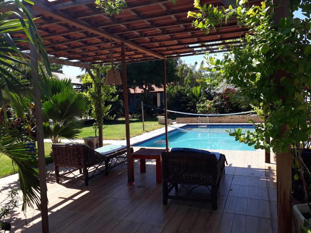 a patio with a table and chairs next to a swimming pool at chácara ouro verde in Beberibe
