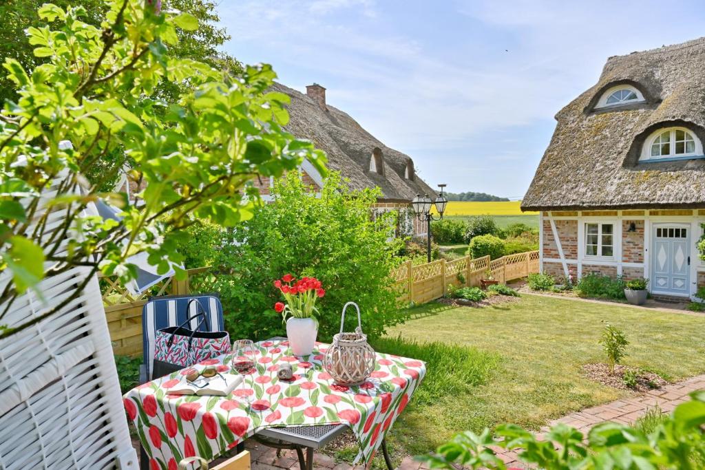 a table in the yard of a house with a garden at Landhaus Vilmnitz - Wohnung 10 in Vilmnitz