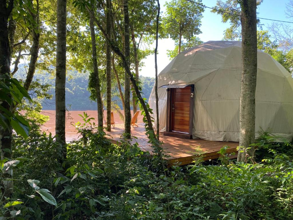a yurt with a wooden deck in the woods at Reserva La Mision Mocona - Solo Adultos in Saltos del Moconá