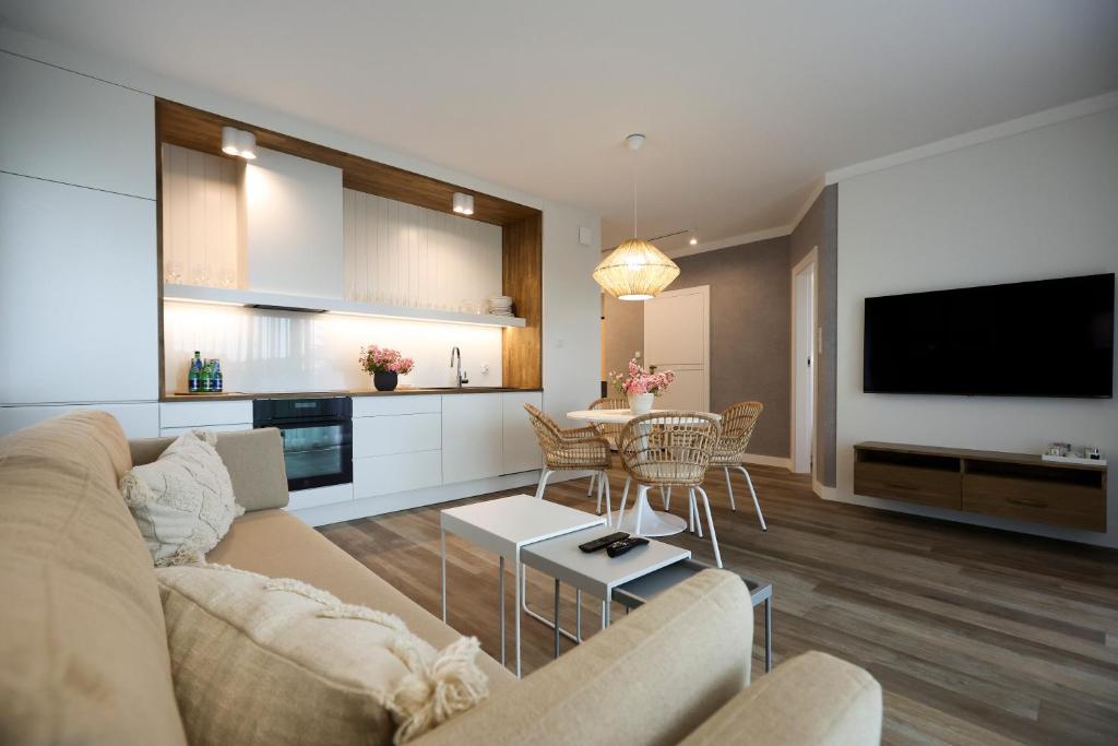 uma sala de estar com um sofá e uma mesa em Villa Park Apartament em Ostróda