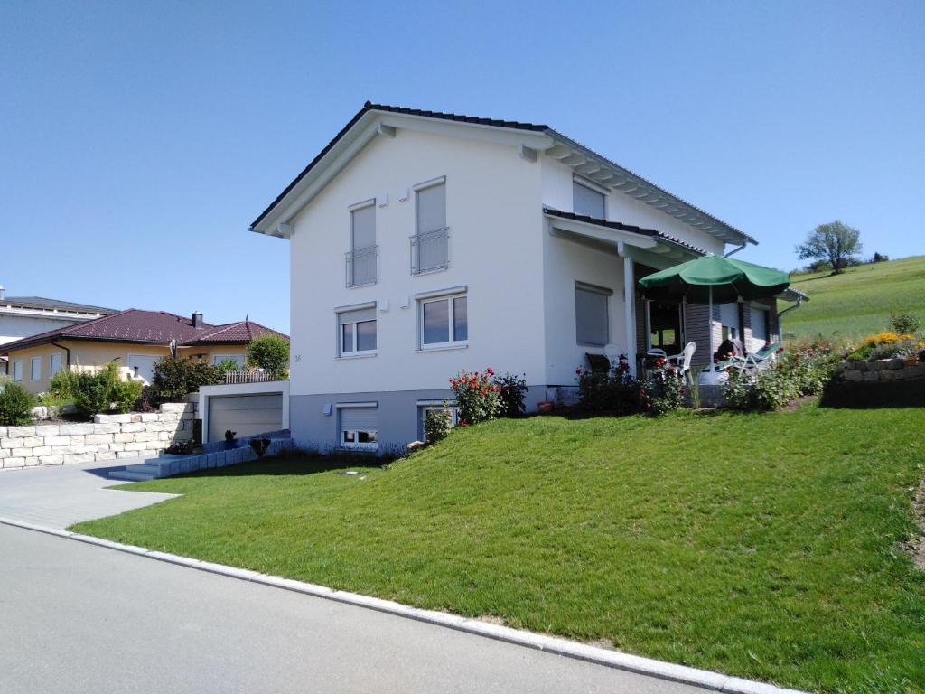 a white house on top of a grassy hill at Eva's Ferienwohnung in Bonndorf im Schwarzwald