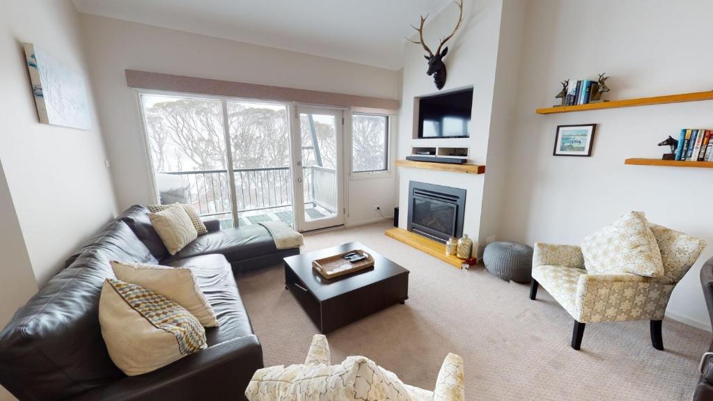 a living room with a couch and a fireplace at Lodge Apartment 25 The Stables in Perisher Valley