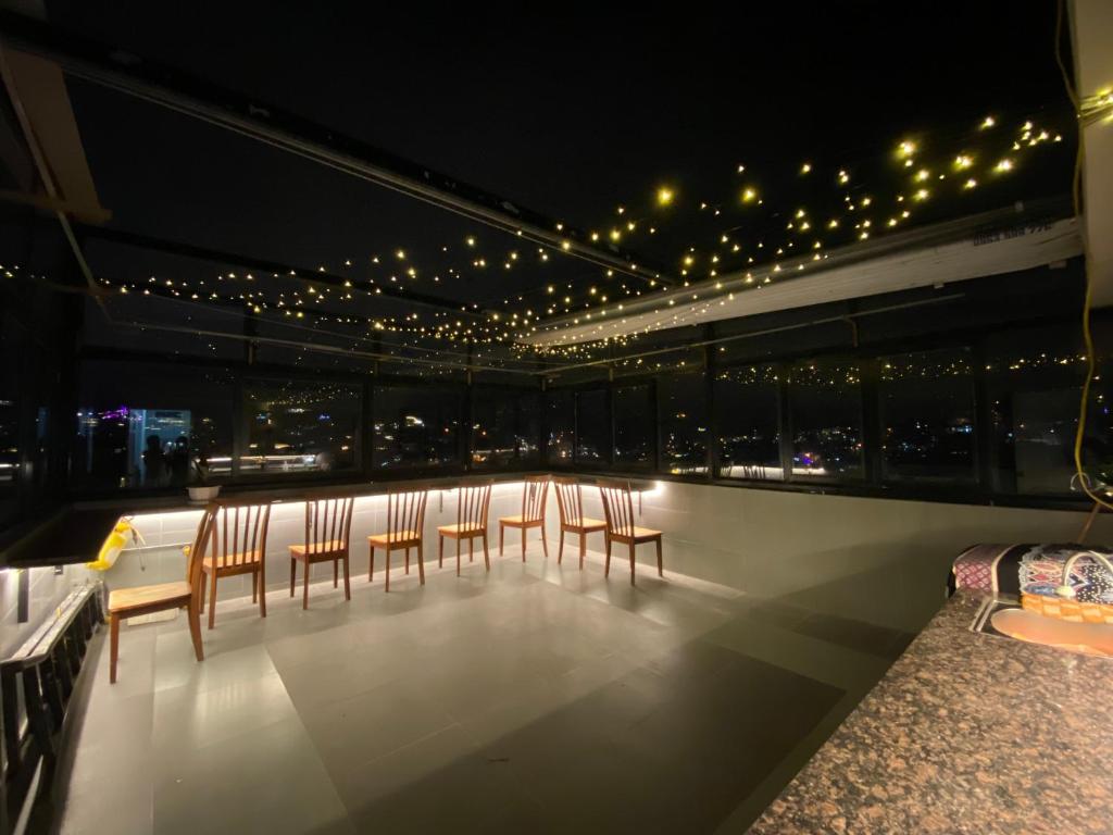 a balcony with chairs and lights on a building at Grey House in Da Lat