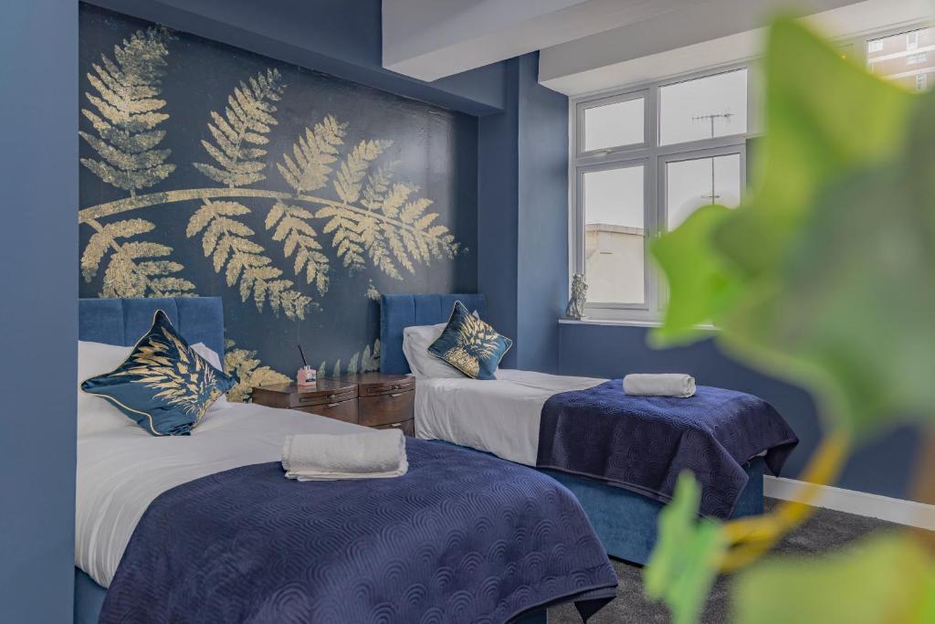 Habitación azul con 2 camas y ventana en Sea View*Morden Central Brighton* Two Bedroom Flat *Roof Terrace* en Brighton & Hove