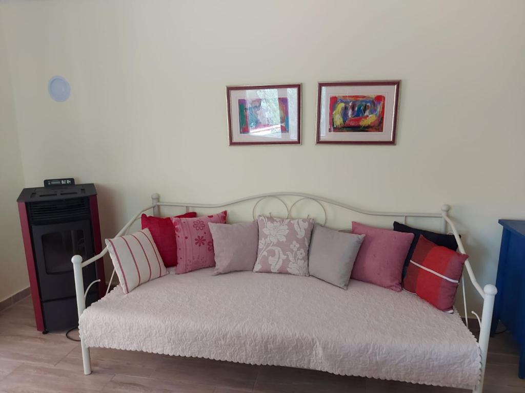 a couch with many pillows on it in a room at Premantura Studio apartman in Premantura