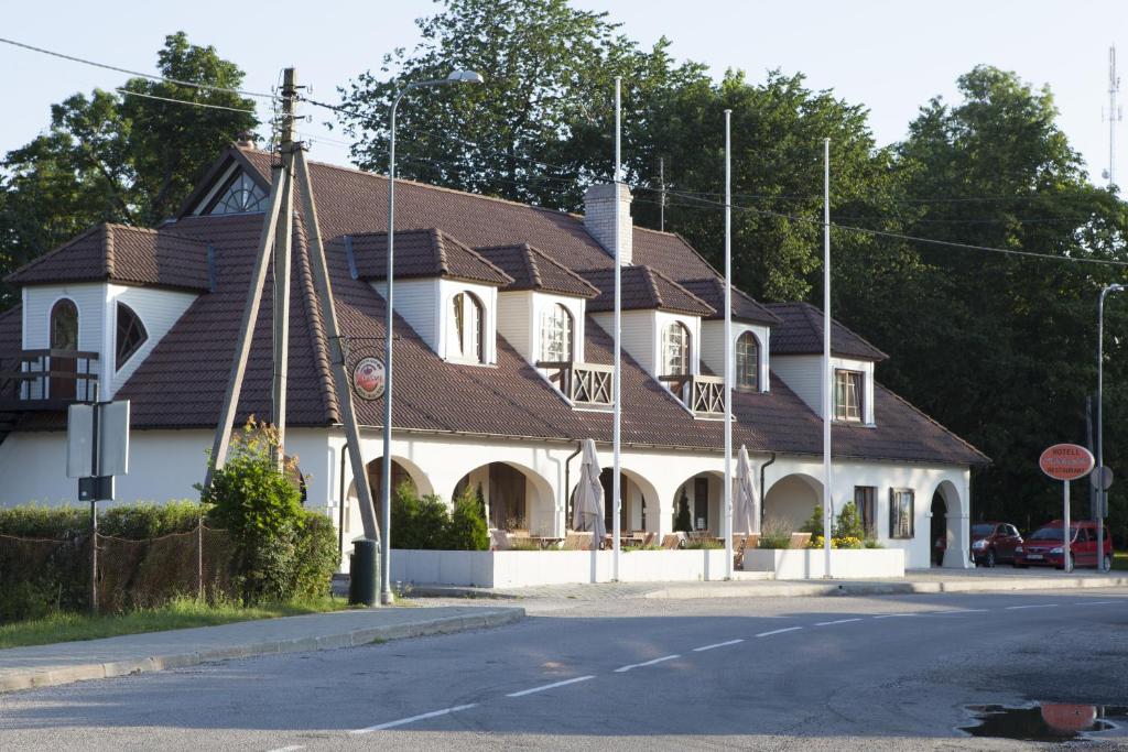 ein großes weißes Haus mit braunem Dach in der Unterkunft Hotel Liilia in Käina