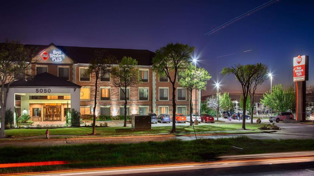 a building on the corner of a street at night at Best Western Plus DFW Airport Suites in Irving