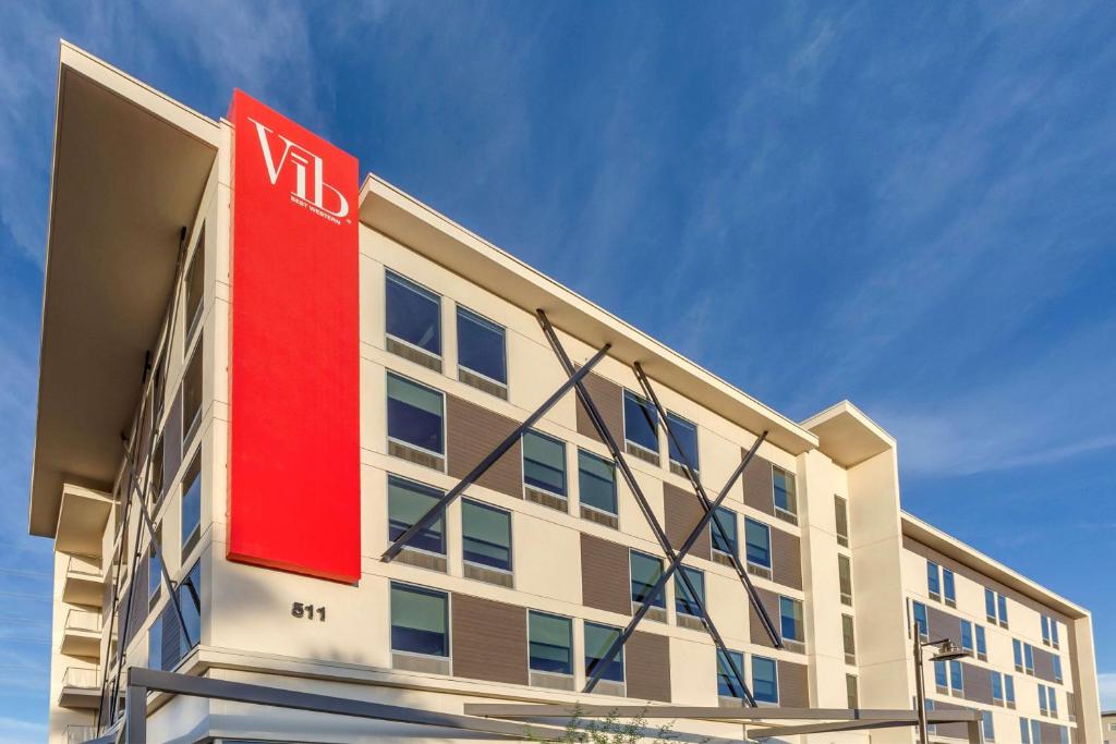 a building with a red sign on the side of it at Vīb Hotel by Best Western Phoenix - Tempe in Tempe