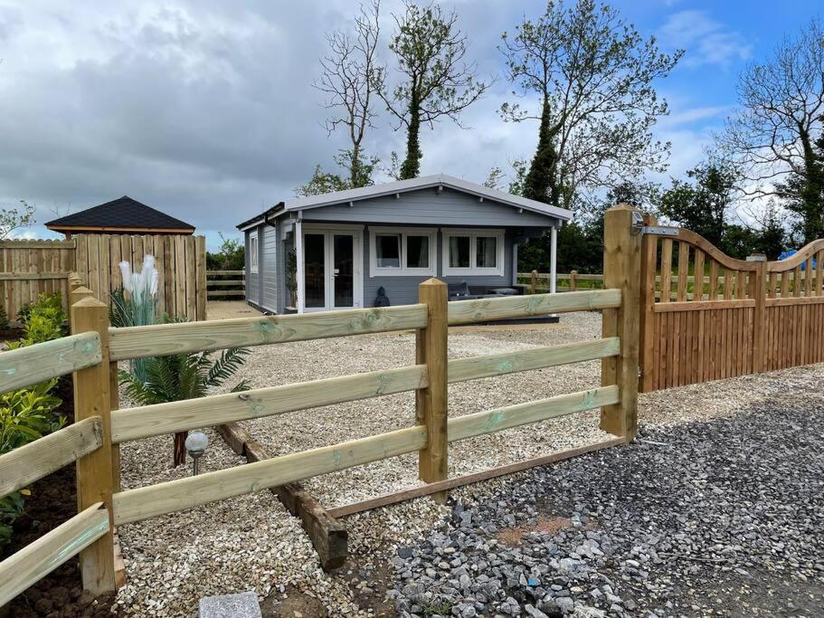 uma cerca de madeira com uma pequena casa atrás dela em Hilltop Hideaway em Donegal