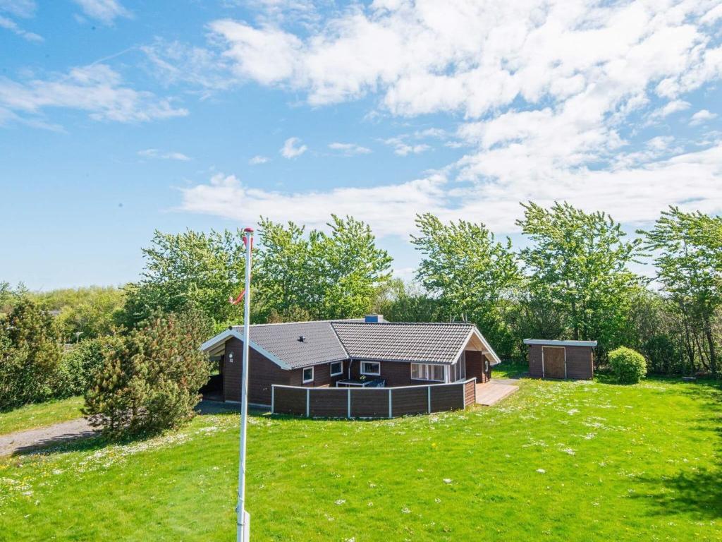 a small house in a field with a green yard at 4 star holiday home in Hemmet in Hemmet