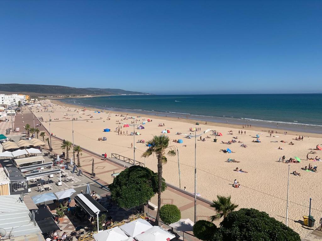a beach with a lot of people and the ocean at Apartamento con garaje en Paseo Marítimo de Barbate in Barbate
