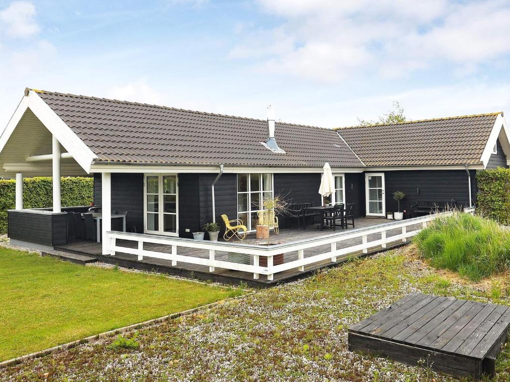 a blue house with a large wooden deck at 6 person holiday home in Otterup in Otterup