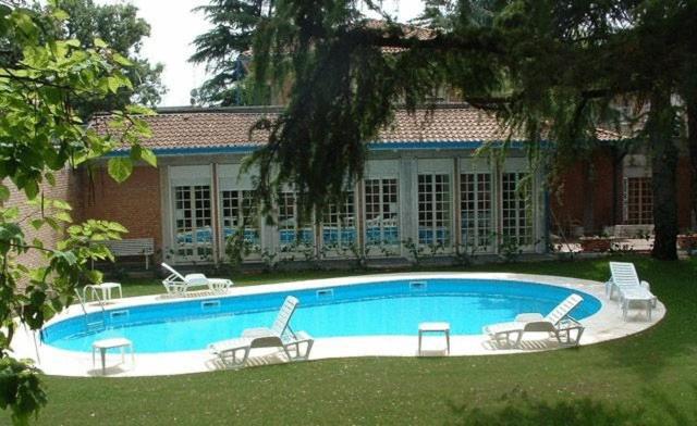 - une piscine avec des chaises et une maison dans l'établissement Park Hotel, à Reggio d'Émilie