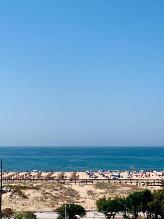 uma praia com muitos guarda-sóis e o oceano em Apartamento T1 Monte Gordo em Monte Gordo