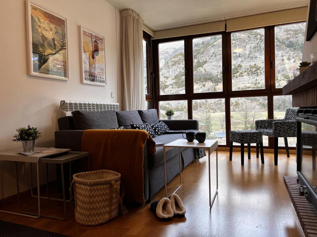 un soggiorno con divano e tavolo di Escarra - Reformado, acogedor y luminoso, con garaje cubierto y ascensor a Escarrilla