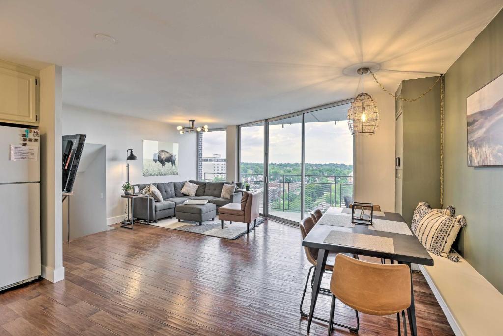 a kitchen and living room with a table and chairs at 7th-Floor Omaha Condo with Balcony and Park Views in Omaha