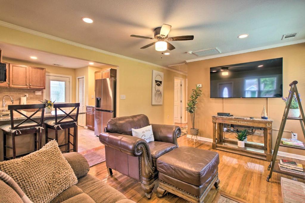 a living room with a leather chair and a tv at Updated Savannah Hideaway with Luxury Backyard! in Savannah