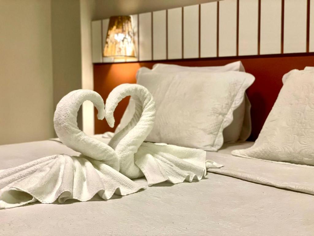 two white swans are sitting on top of a bed at Gran Lençóis Flat Barreirinhas APT 510 in Barreirinhas