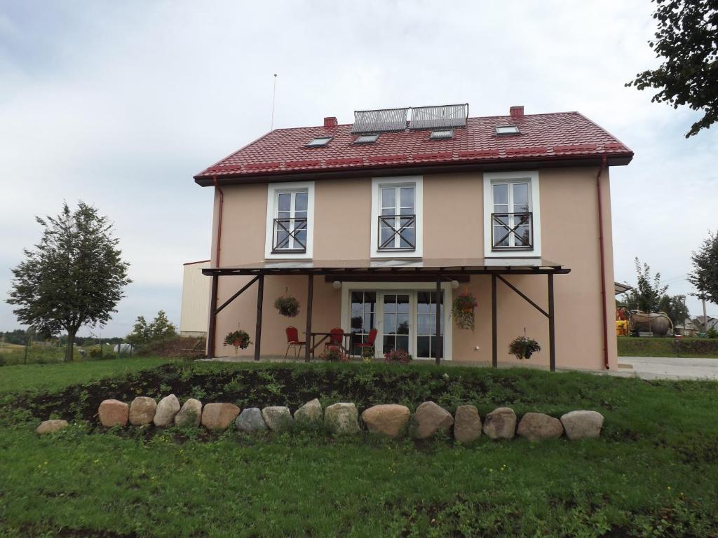 a small house with a red roof at Kaimo turizmas "Svečių namai Moteliukas" in Alytus