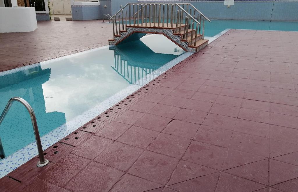 een zwembad met water en een trap in een gebouw bij DUNES DE MARTIL in Martil