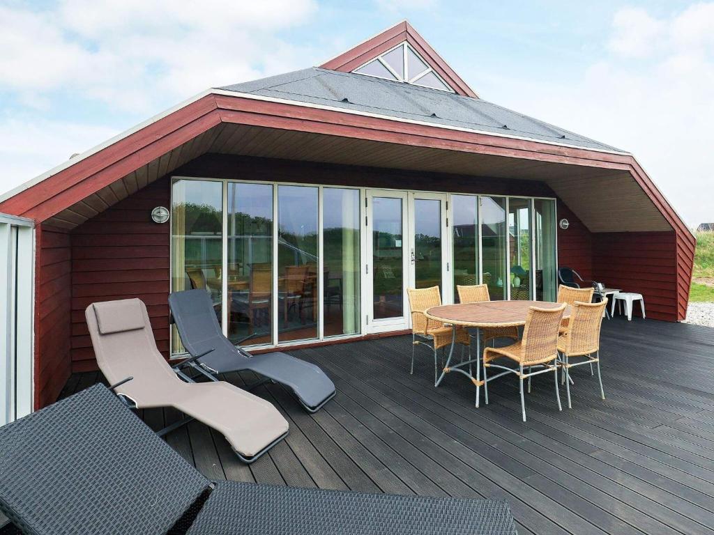patio ze stołem i krzesłami na tarasie w obiekcie 8 person holiday home in L kken w mieście Løkken