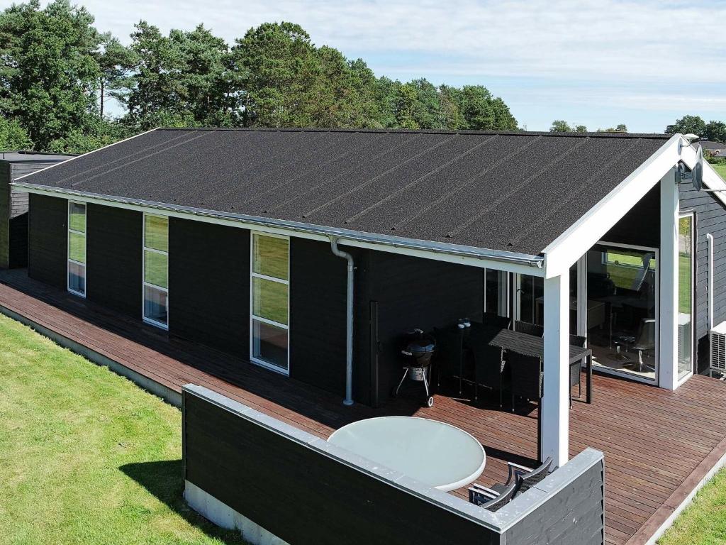 Haslevgårde的住宿－Holiday Home Haslevgårde，甲板上白色屋顶的黑色房子