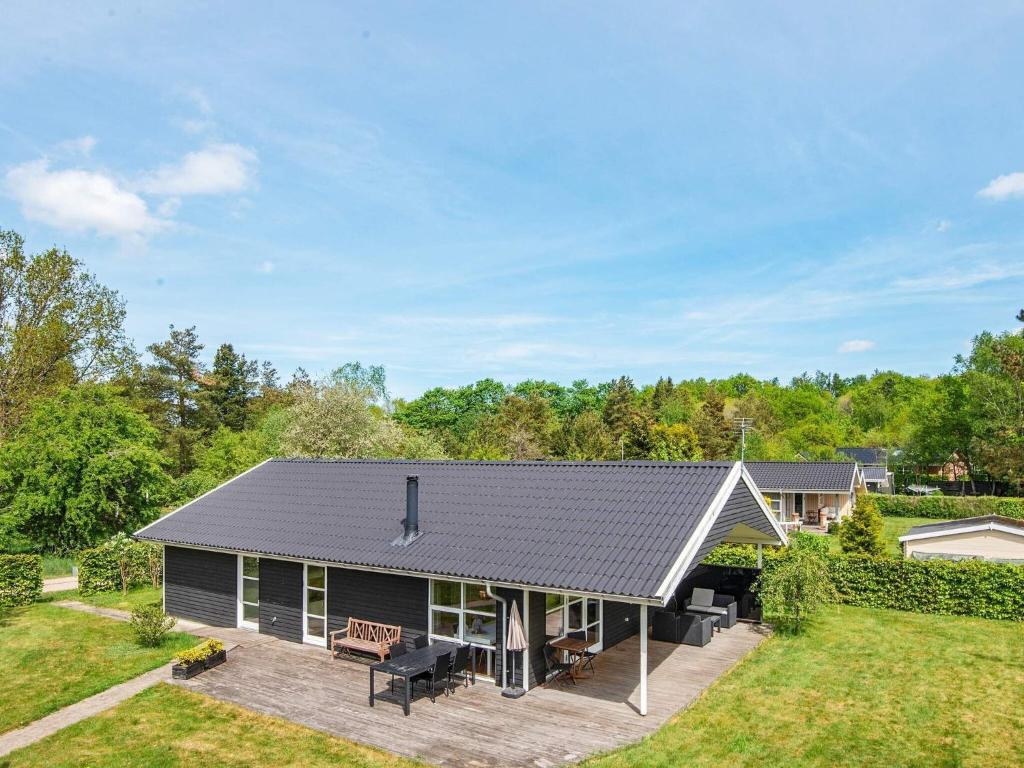 a house with a black roof and a yard at 8 person holiday home in Silkeborg-By Traum in Silkeborg