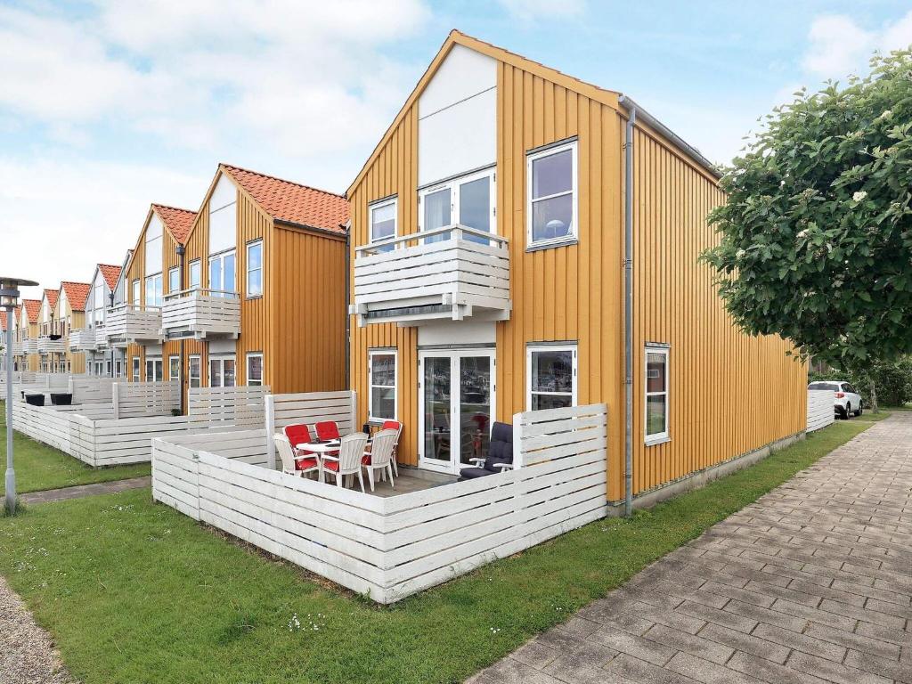 una fila de casas de color blanco y naranja en 4 person holiday home in Rudk bing, en Rudkøbing