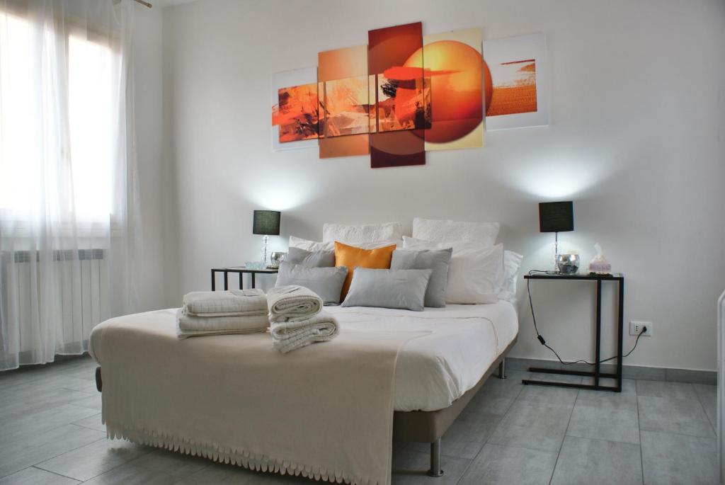 1 dormitorio con 1 cama blanca grande con almohadas de color naranja en 4-Tourist House Bologna-Studio - Self check-in en Bolonia