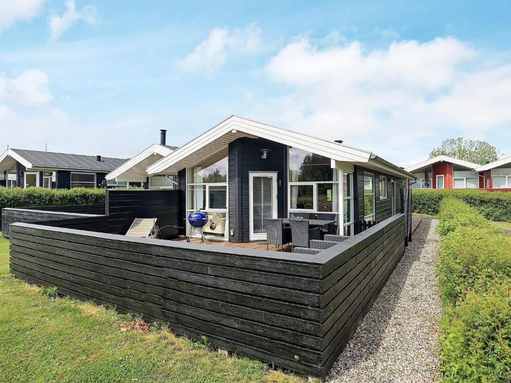 una pequeña casa con una gran terraza en un patio en Holiday home Tranekær XXXII, en Tranekær