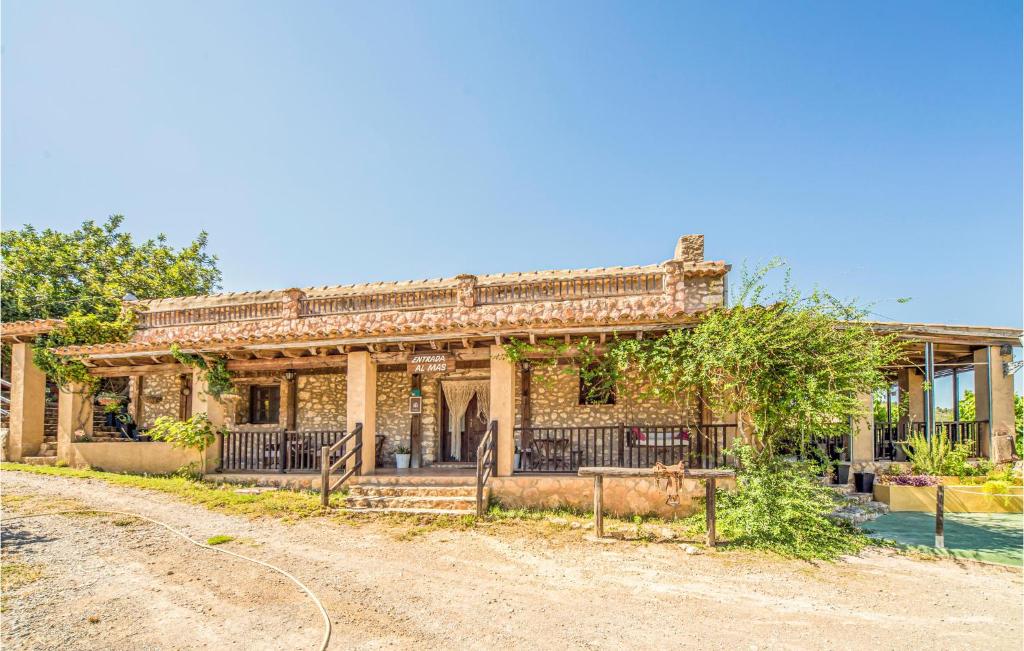 Gorgeous Home In Les Coves De Vinrom With Private Swimming Pool, Can Be Inside Or Outside في Les Coves de Vinroma: منزل من الطوب القديم مع بوابة على طريق ترابي